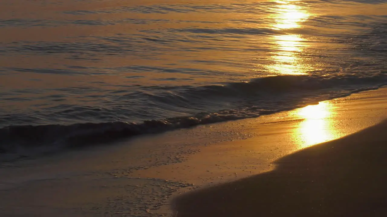 Waves on sandy shore on calm morning at sunrise mediterranean spain