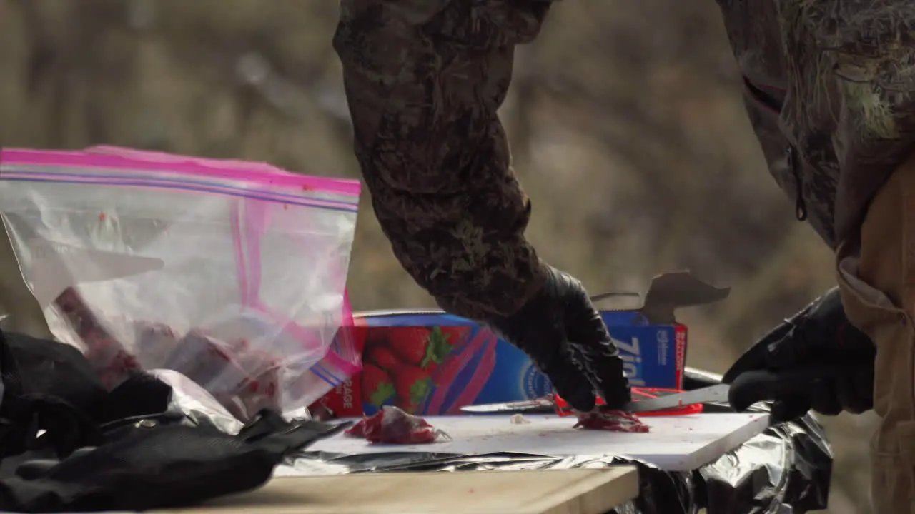 Hunter Preparing Deer Meat On Table By Cutting It Into Pieces