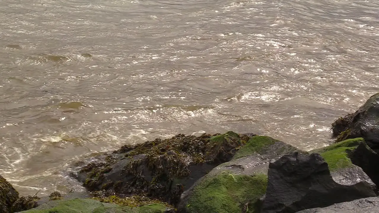 Close up of the Irish sea crashing up against rocks