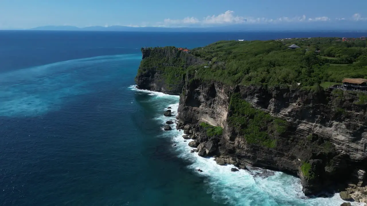 Ocean waves moving toward the cliffs on the coast of Uluwatu in Bali Indonesia