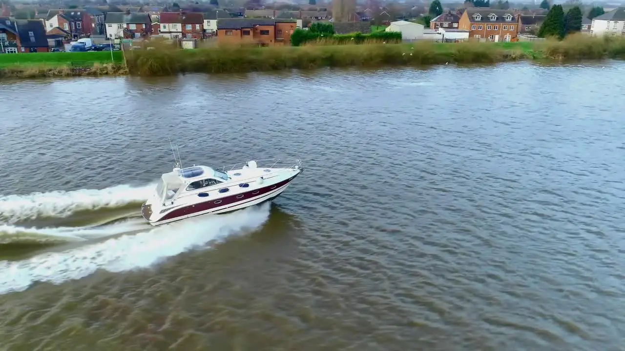 Side view of a speedboat as it cruises down the river and creates huge waves