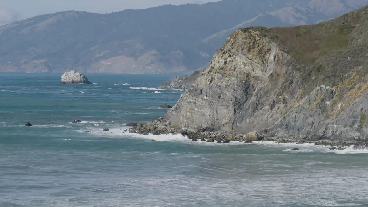 beach level view of waves crashing along the boulder lined shore of Big Sur Southern California Beach