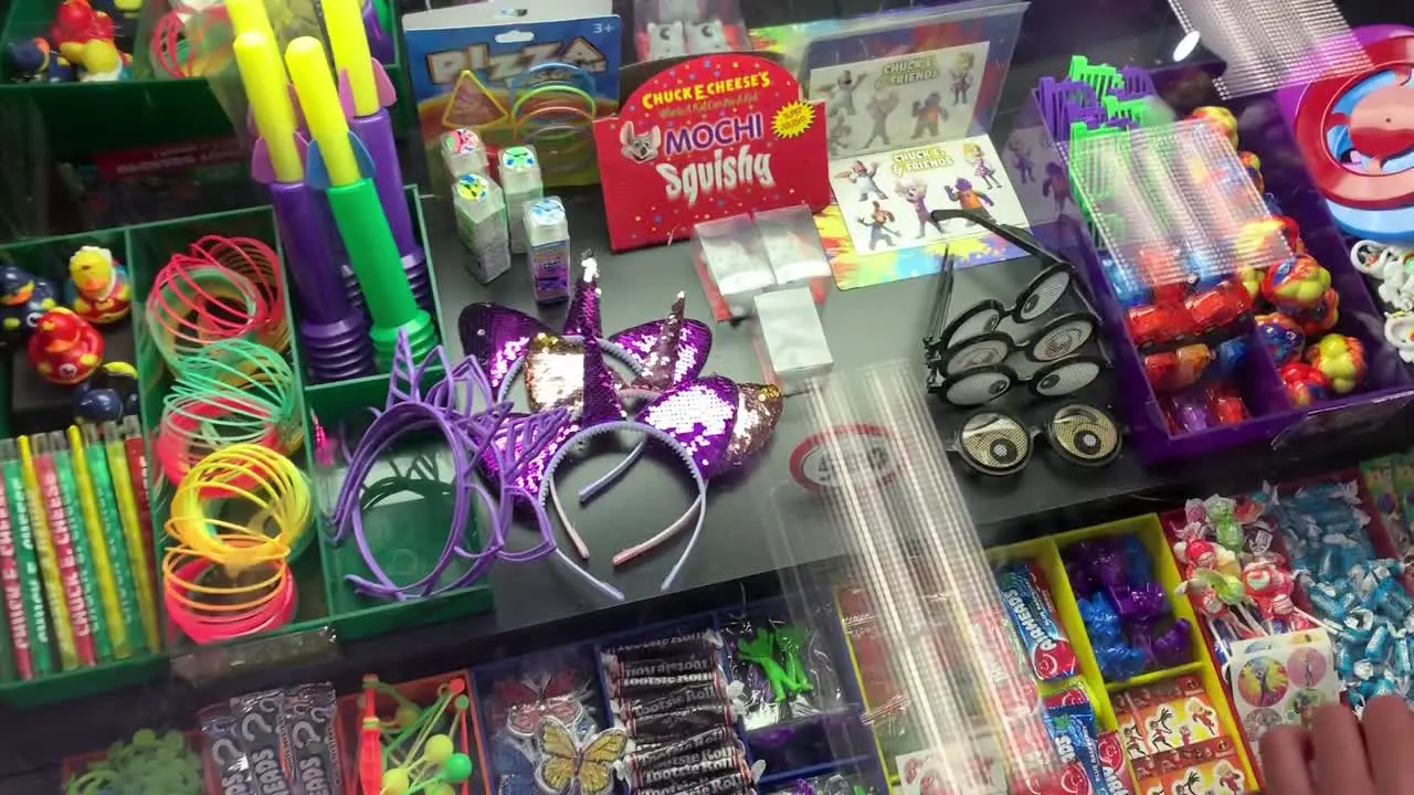 A boy looking into a glass case full of prizes to be exchanged with his game winning tickets