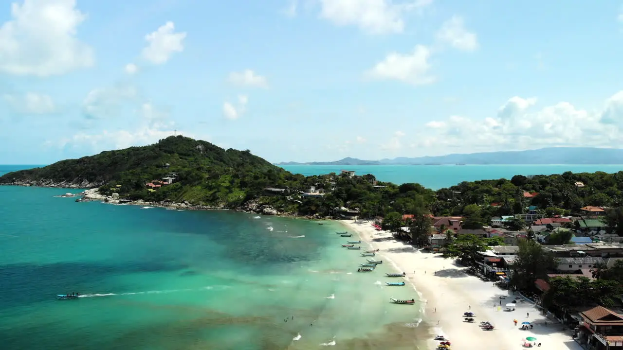 Aerial view of a beach in Thailand with boats and people walking