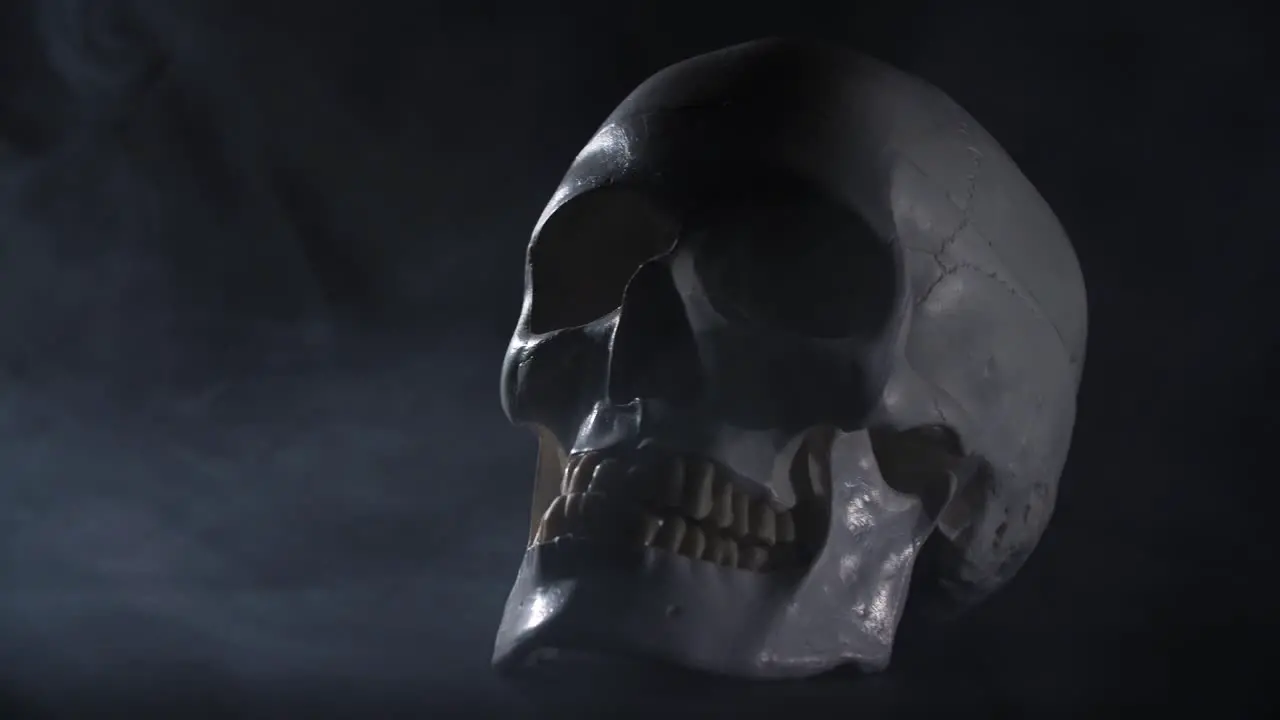 Slider shot of a human skull on a black smokey background