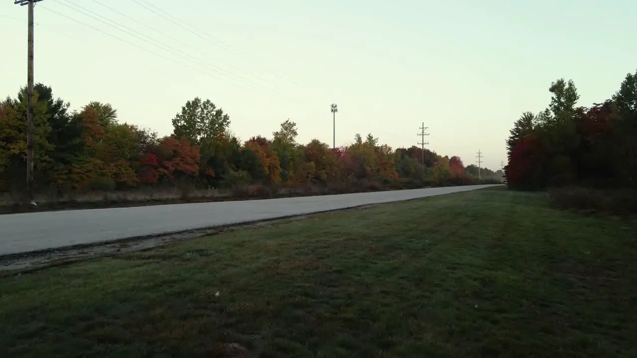 Deep fall colors filling the trees as a drone lands nearby in reverse descent