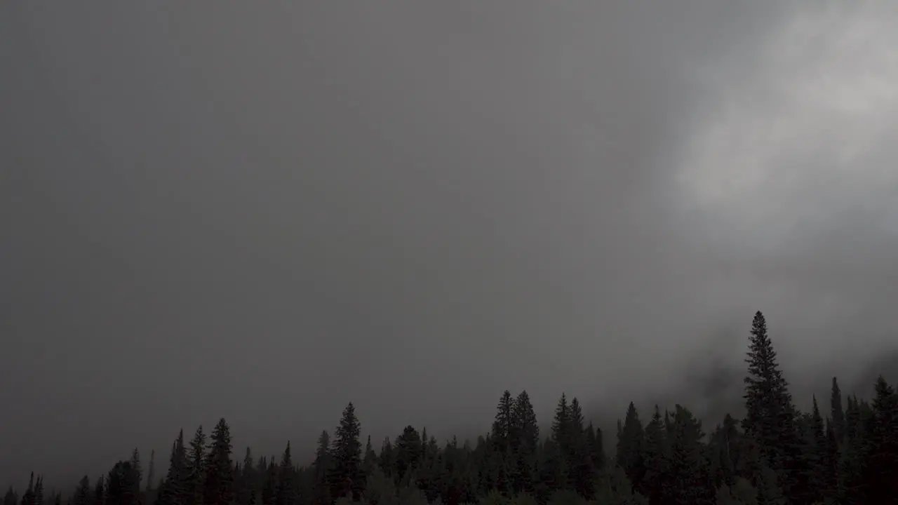 Time lapse of dark storm clouds rolling through mountains