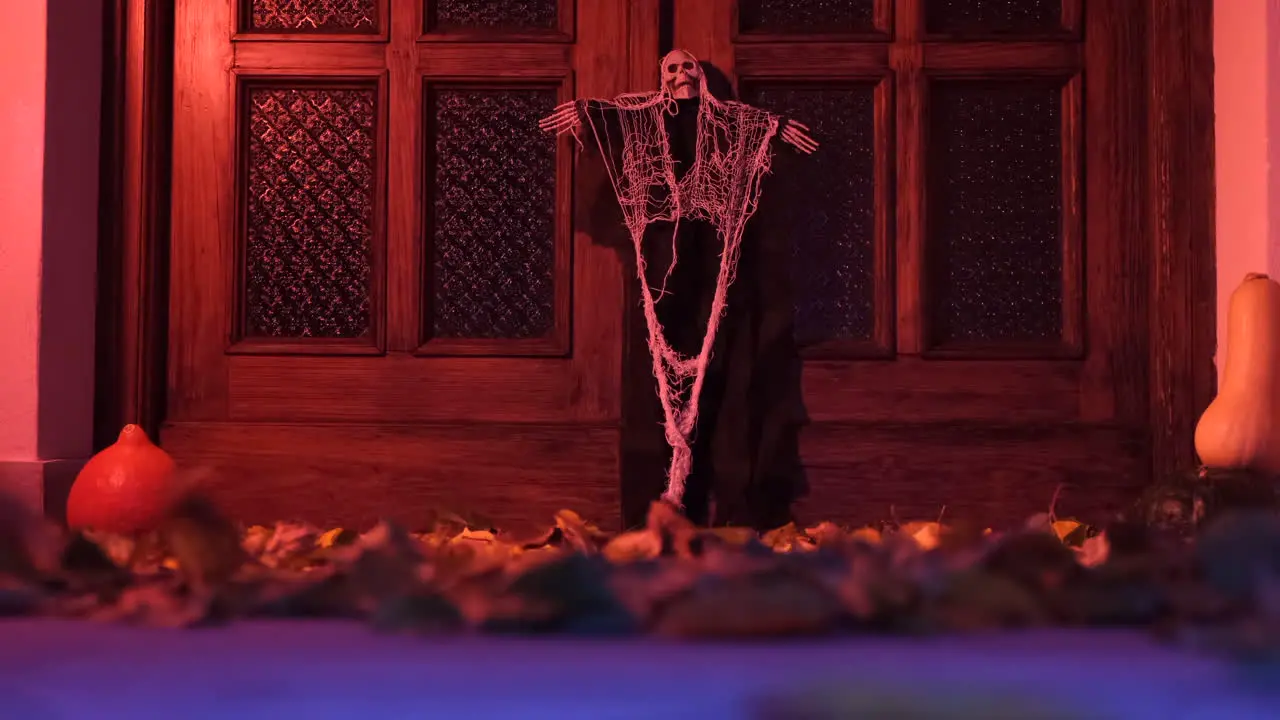 Halloween home door decoration with autumn foliage moved by the wind