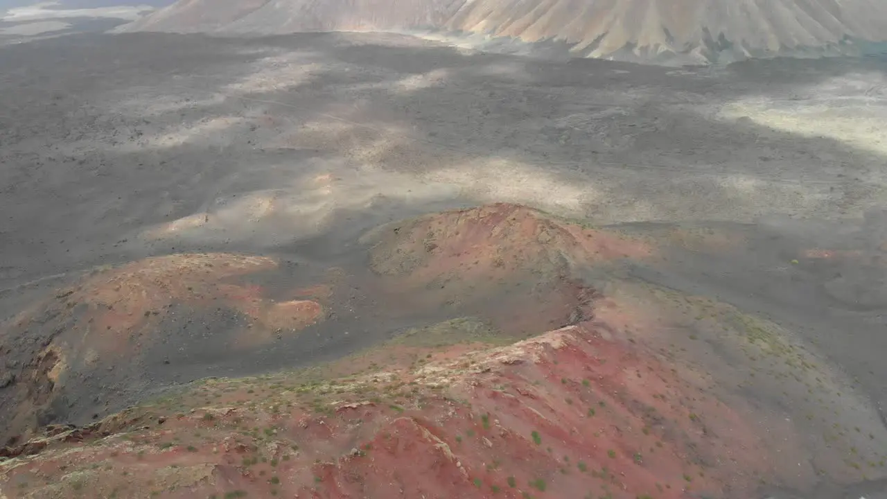 Aerial view of a red volcanic landscape on a cloudy day