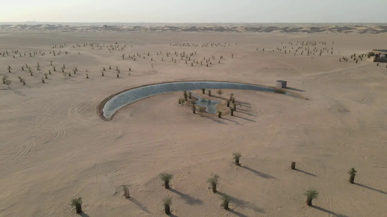 Drone view of the Moon Lake in Dubai Moon Shape Lake is in the middle of Al Qudra desert surrounded by golden sand dunes in the United Arab Emirates