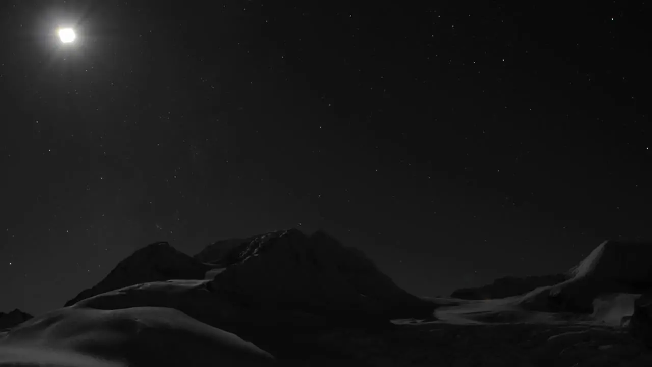 Moon setting behind mountain