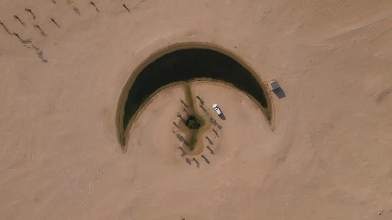 Top view of the Moon Lake in Dubai Moon Shape Lake is in the middle of Al Qudra desert surrounded by golden sand dunes in the United Arab Emirates