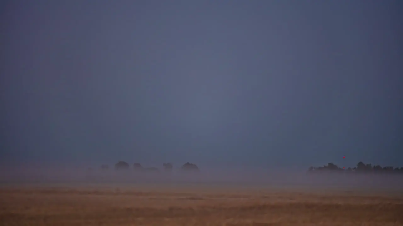 A misty fog creeps in over farmland then a super moon rises an illuminates the countryside time lapse