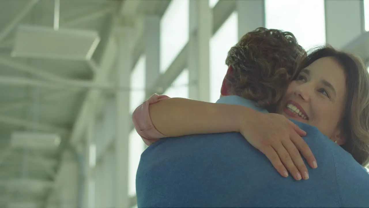 Back View Of The Man Hugging His Pretty Happy Wife Or Girlfriend When They Meeting In The Airport