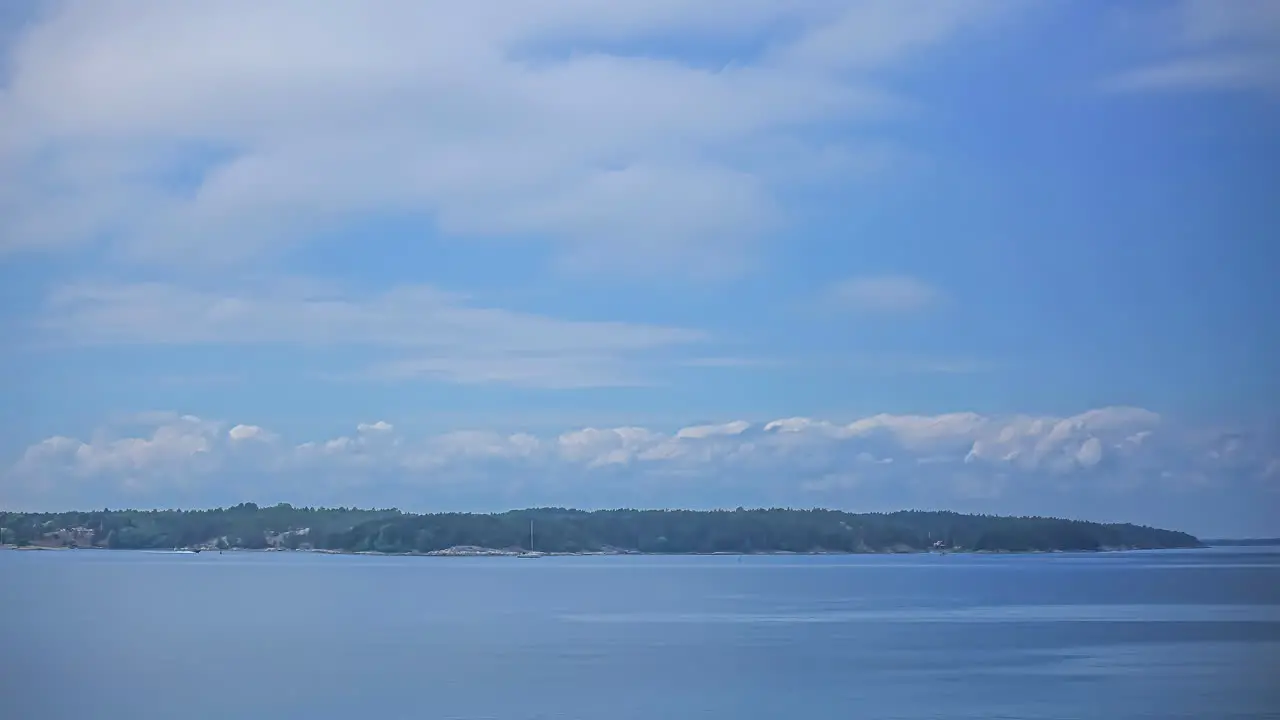 Time lapse shot of boat activity along Swedish coastline beautiful blue sky with fluffy white clouds