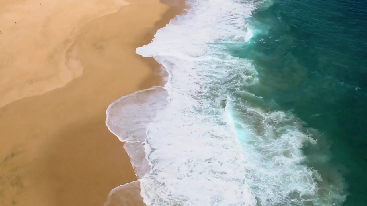 Aerial drone shot of waves crashing into shoreline