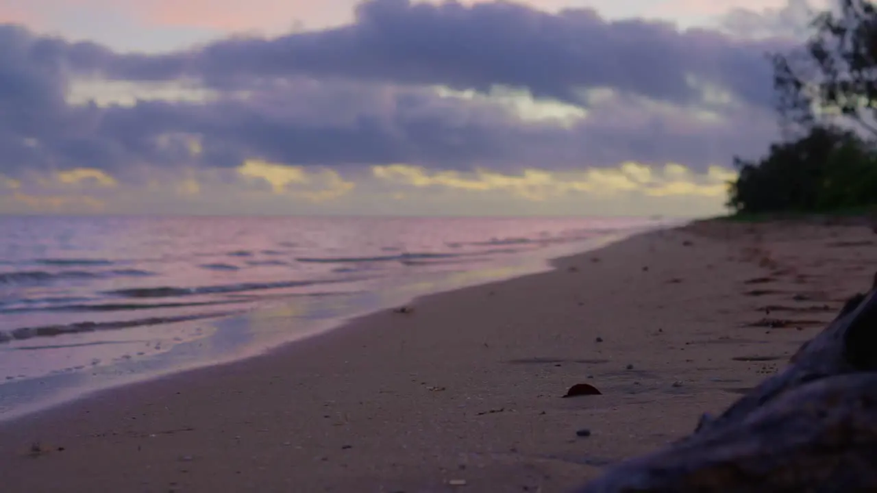 A sunset at an abandoned beach with a log in the middle