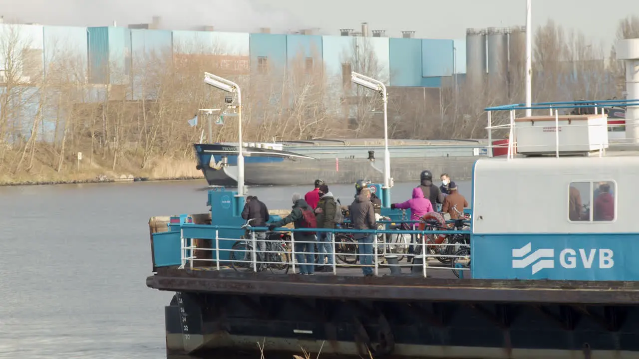 People on deck of Amsterdam ferry waiting for boat to cross river