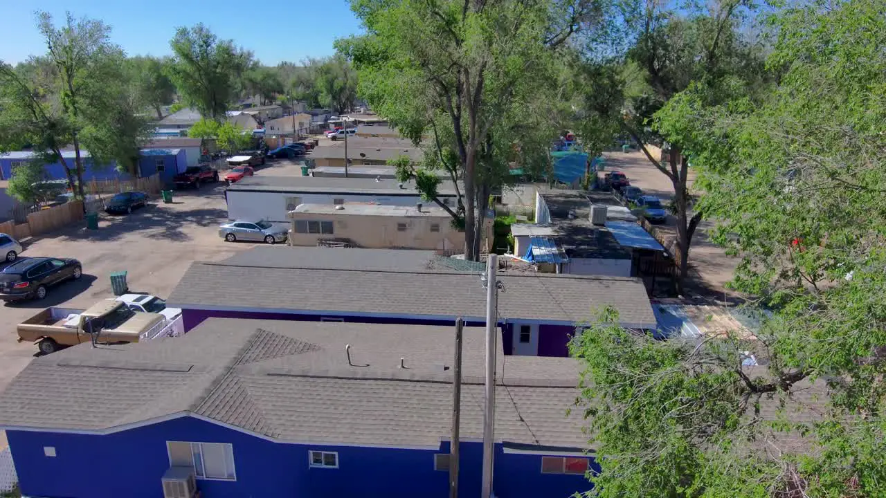 A rising poor neighborhood shot with a car driving down the street