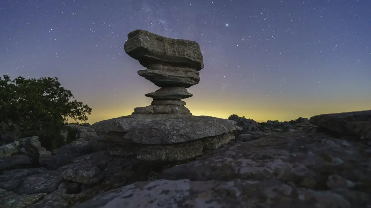 Tree and rock formation against night sky