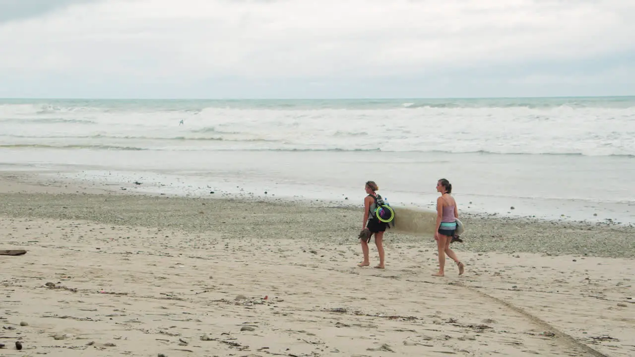 Slow Motion Back Shot Two Young Female Surfers Holding Surf Board Walk Along the Beach in Tambor Costa Rica