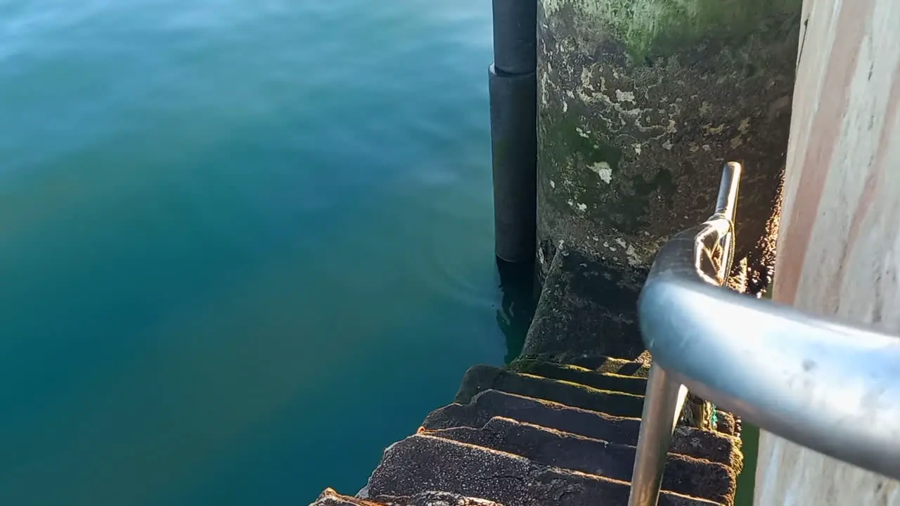 Small stairs that descend from the pier to the sea with an iron protection