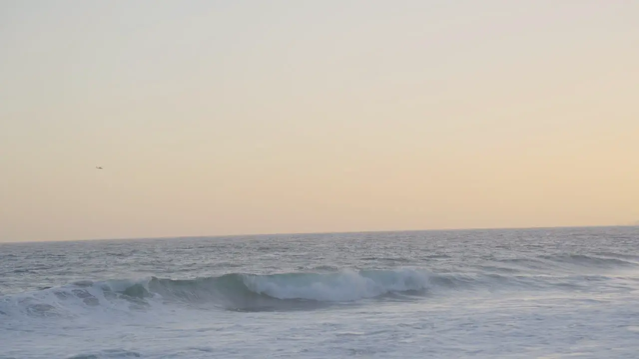 slow motion of waves rolling through the ocean at sunset