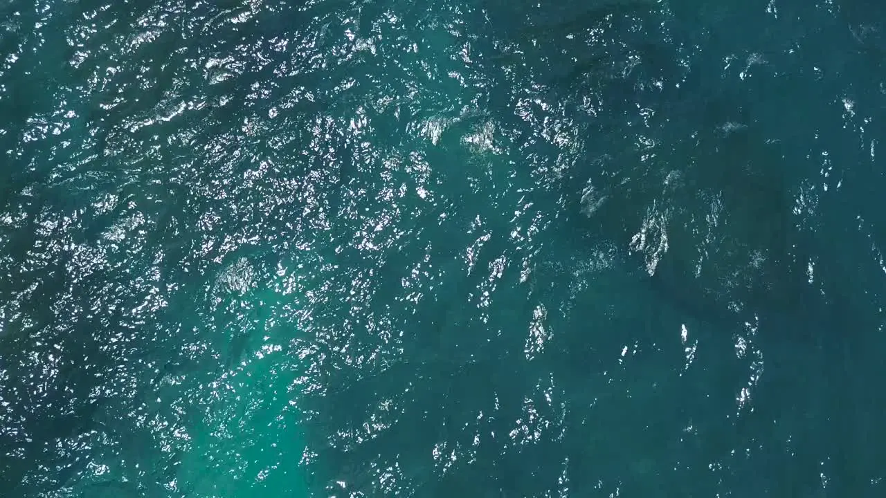 Aerial view of the waves of crystal blue water on shore line of diamond beach in Nusa Penida Indonesia