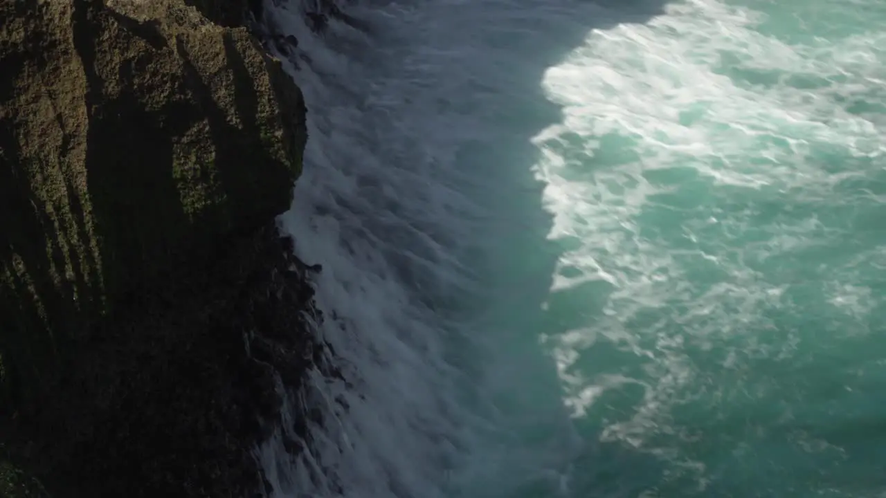 Aerial view of the crystal blue water of Angels Billabong in Nusa Penida Indonesia with the waves hitting the cliffs