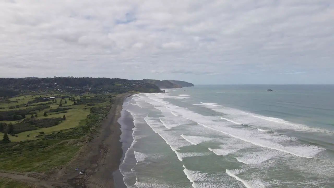 Descending aerial shot above the stunning black sand Muriwai Beach New Zealand