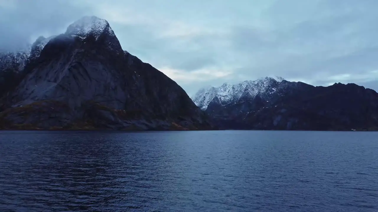 Rocky mountain ridge and wavy sea against gloomy sky in Norway