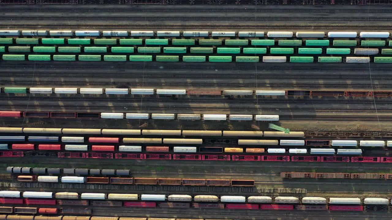 Flying above industrial railroad station with cargo trains and freight containers