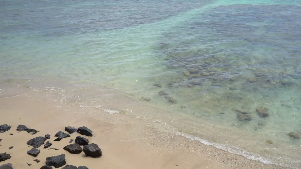 Calm ocean surface and idyllic tropical island sandy beach