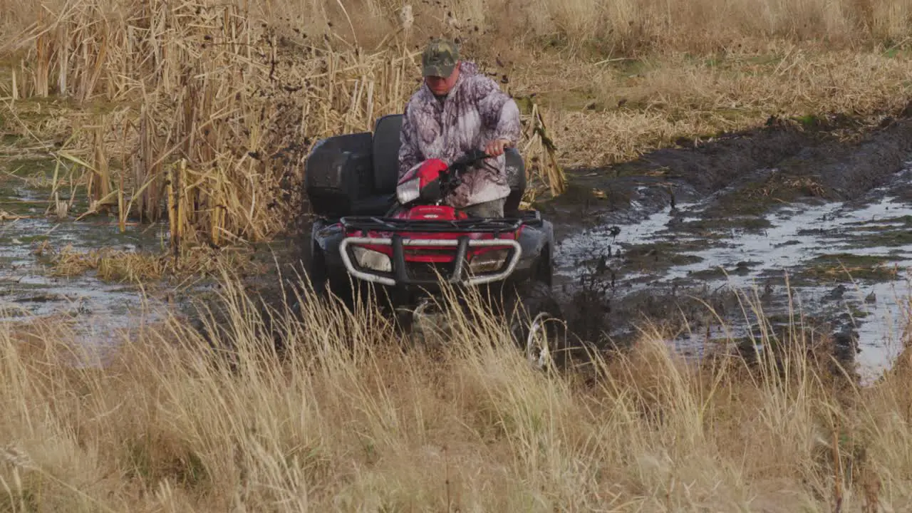 ATV rider stuck in mud tries to get out