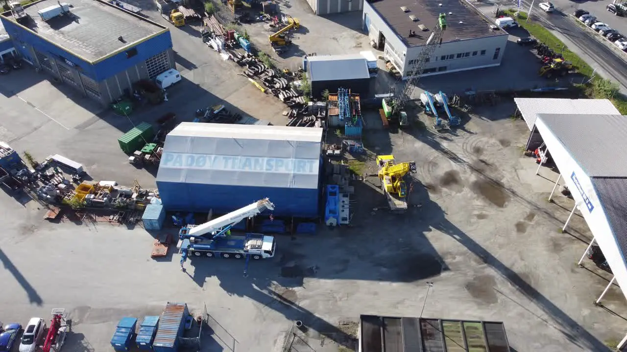 Company Padøy Transport industrial area with logo and machinery parked around Sunny day aerial overview Asane Bergen Norway