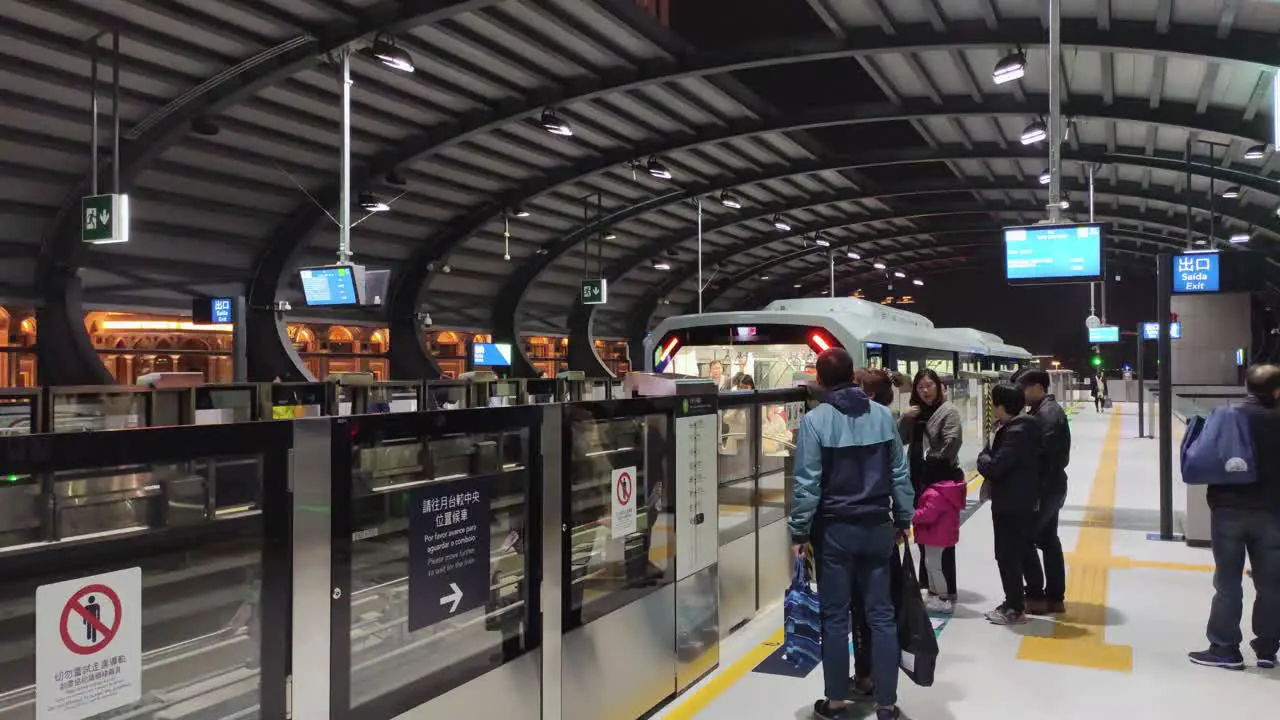 Macau Light Rapid Transit train arrives at the station as passengers wait to board