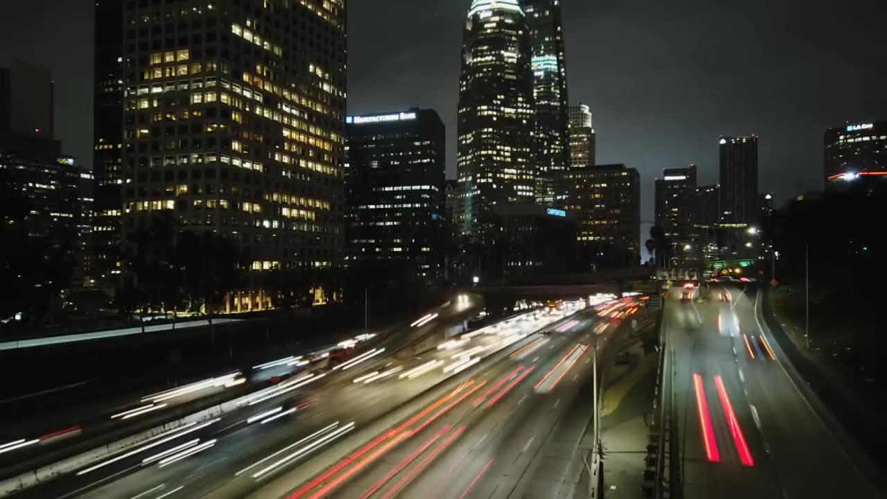 Time lapse downtown Los Angeles over freeway with traffic nighttime city view panning left