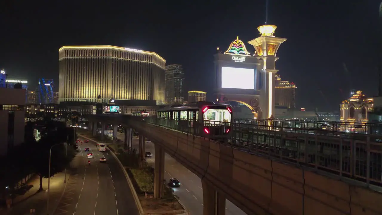 Two Macau Light Rapid Transit trains pass each other in front of Venetian and Galaxy hotels