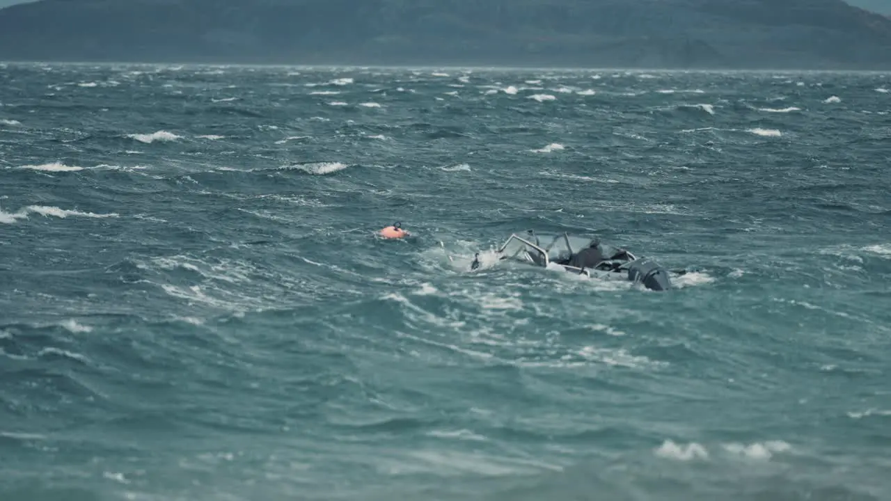 A small motorboat tied to a buoy battling strong wind and powerful waves in the fjord