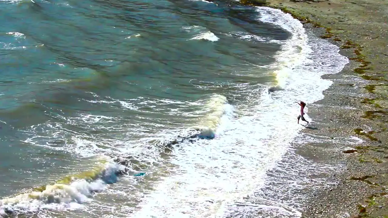 Girl Playing in Waves at Beach