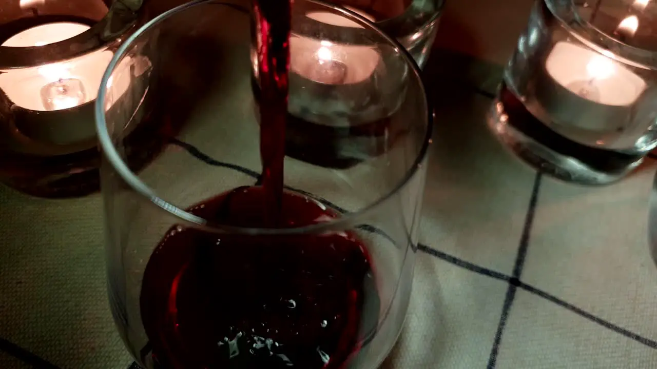 red wine poured into cozy glasses improvised casual friday vibe with round bottom glass and ordinary everyday tablecloth cinematic slider