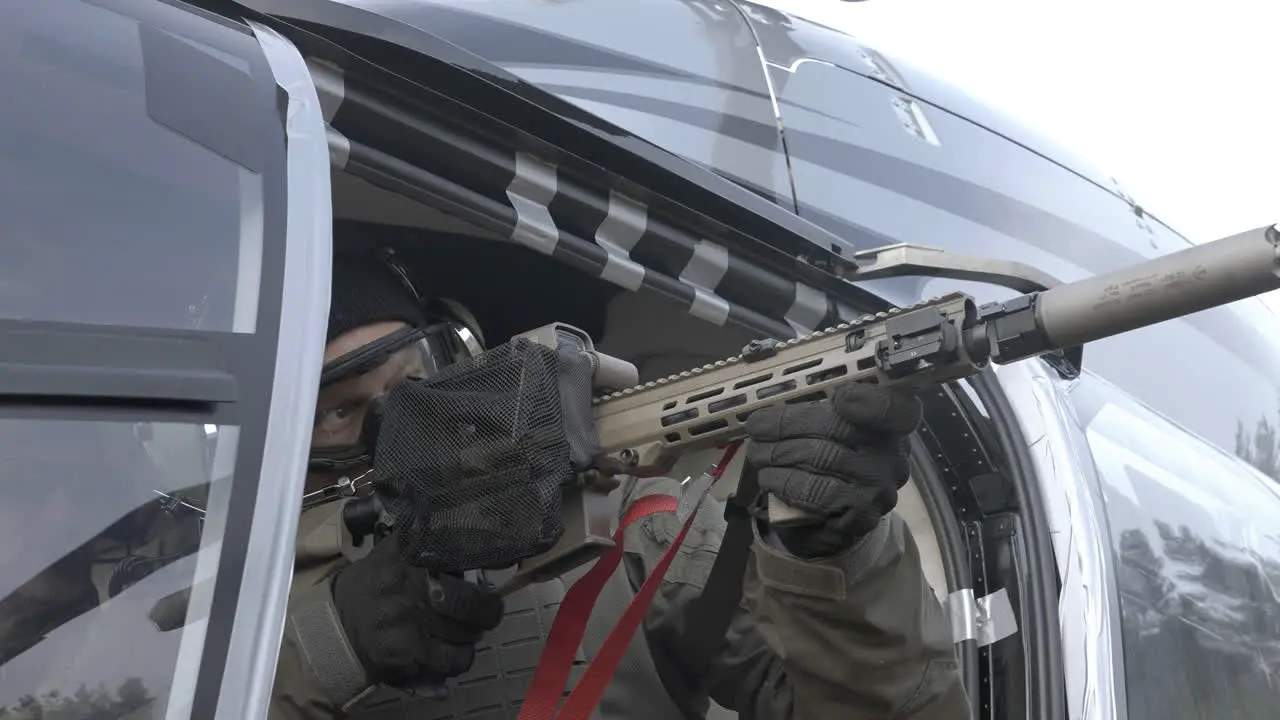 Soldier With Sniper Rifle in Helicopter Pointing at Target Close Up