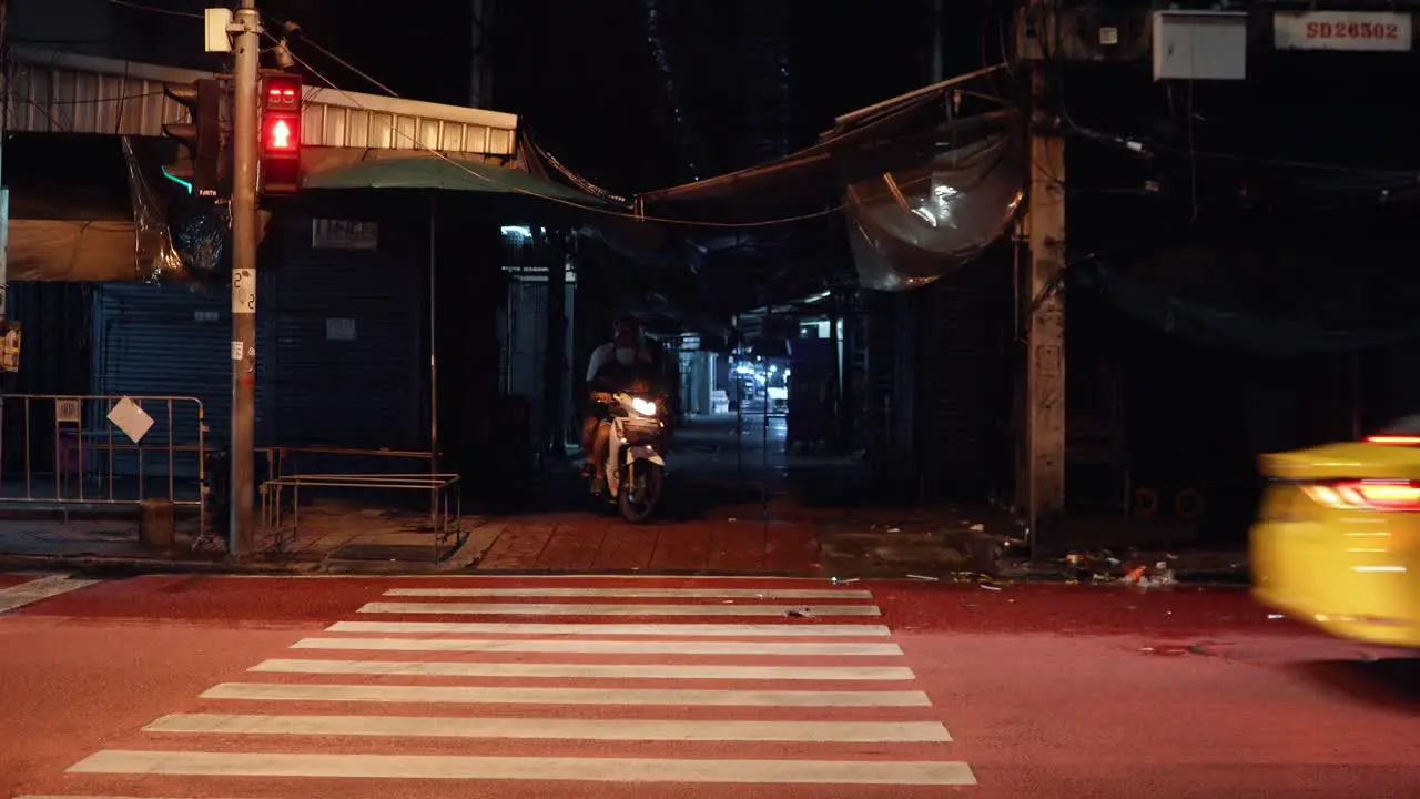 Scooter driving through dark alley in to traffic in Bangkok Thailand