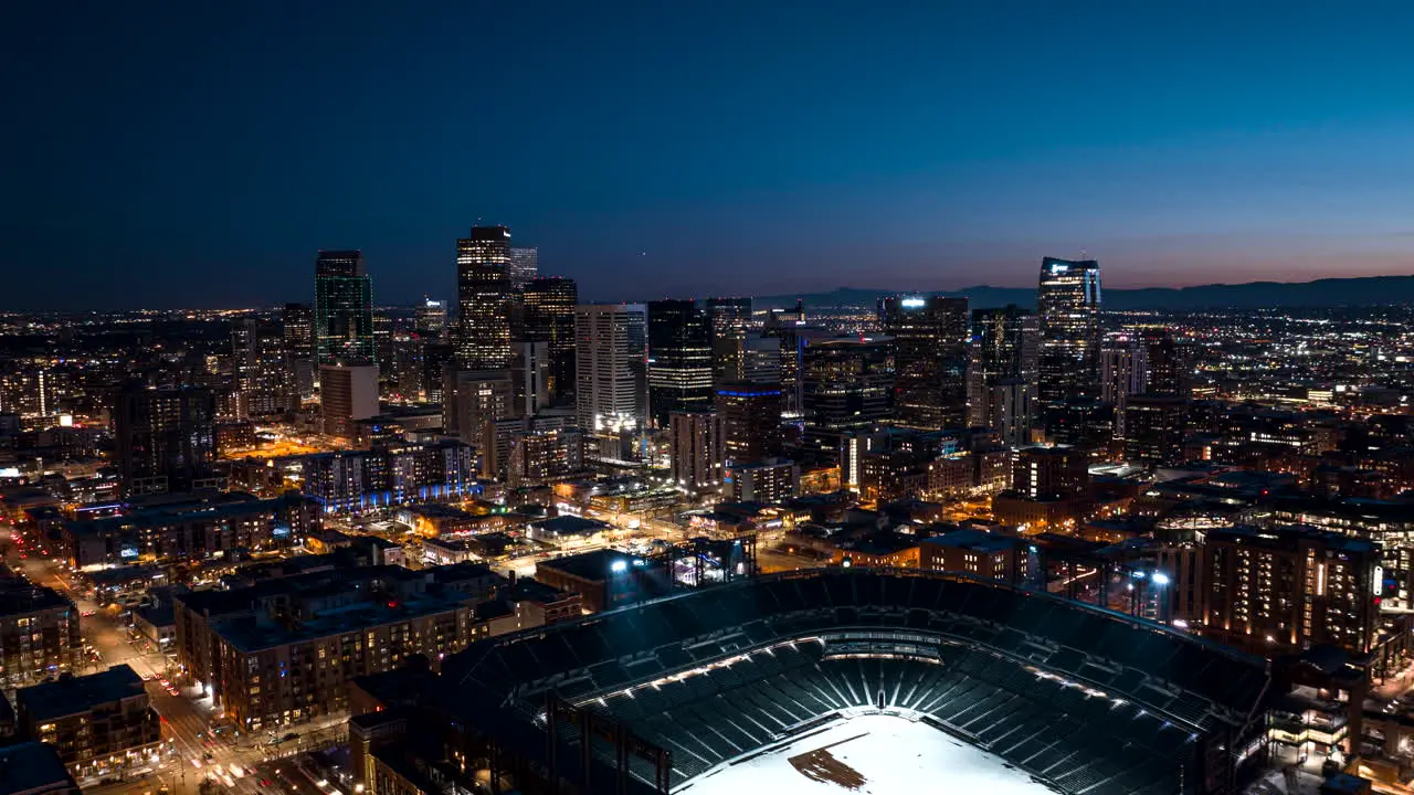 Aerial hyperlapse of downtown Denver at night with traffic-filled streets and the Coors Field getting ready for a baseball game