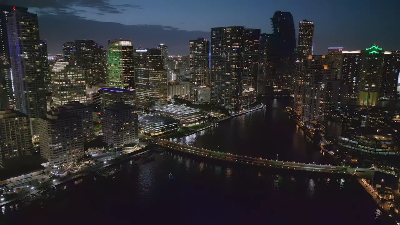 Drone pull back from city centre tall skyscrapers with lights in windows