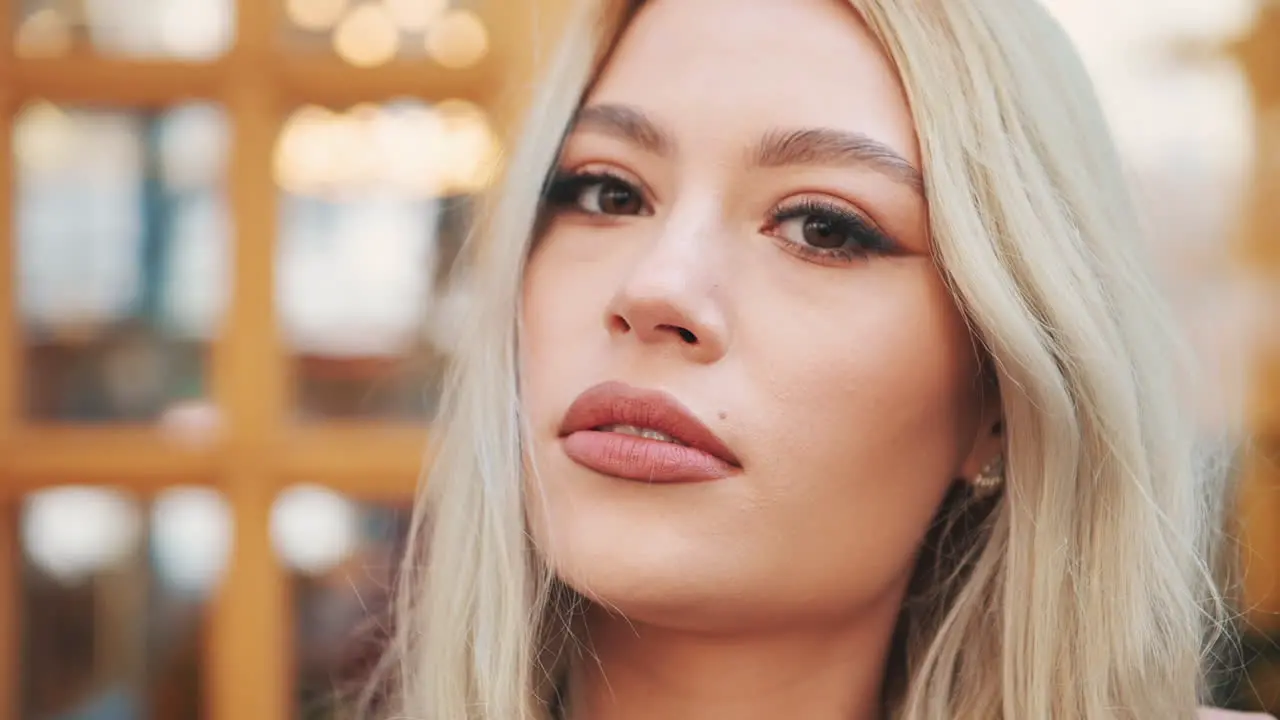 Retrato De Una Mujer Rubia Bastante Joven Con Labios Maquillados Y Manicura Mirando A La Cámara