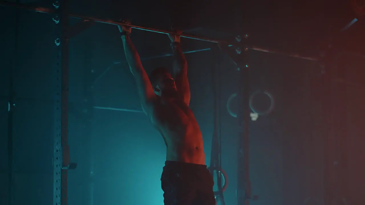 El Hombre Atlético Está Entrenando Duro En El Gimnasio Por La Noche Colgado En La Barra Y Levantando Las Piernas