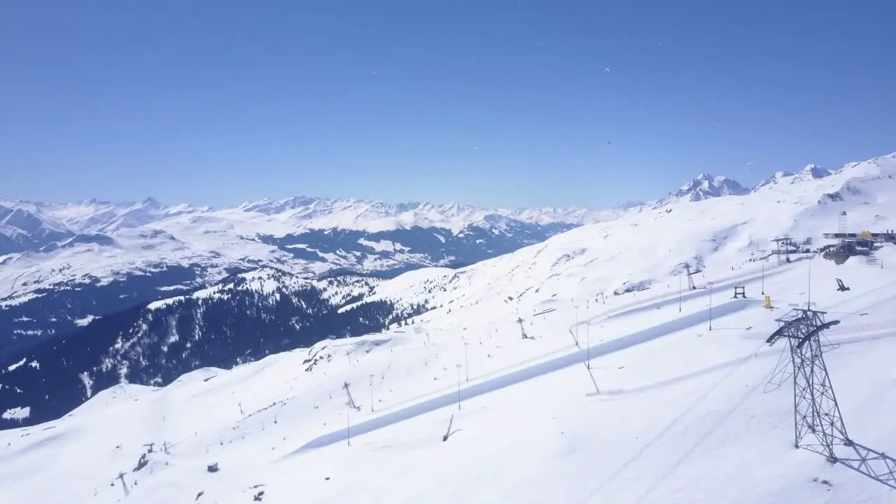 Aerial panoramic footage of ski slopes in winter mountain resort Snow capped mountain ridge in Alps Laax Switzerland