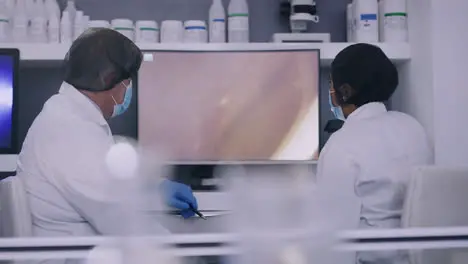 Two scientists looking at cells on a computer