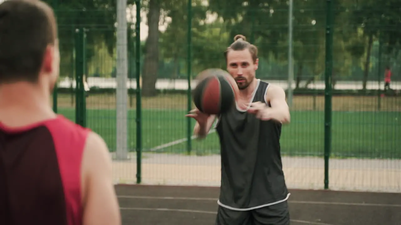 Two Male Basketball Players Passing Ball Each Other During A Training Session In An Outdoor Basketball Court